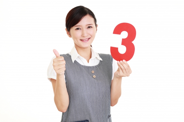 3のカードを持つ若い女性